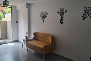 A modern interior with a sofa and wall art depicting animal heads.