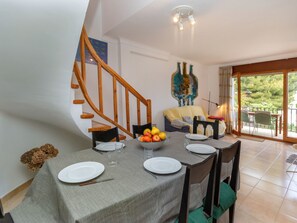 Enjoy meals in this dining area with a table set for four, featuring a bowl of fresh fruit and a beautiful view.