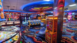 A brightly lit arcade with various gaming machines and a colorful carpeted floor. - Caravan Sleeps 6 With Game Console (Skegness)