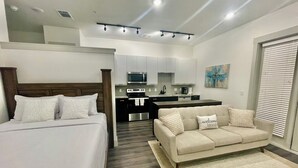 Eine moderne Wohnung mit Schlafzimmer, Wohnbereich und Küche.