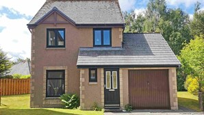 A two-story house with a garage, a front door, and a small porch area. - Birch View -  Retreat Group (Aviemore)
