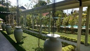 Un espacio al aire libre cubierto con macetas grandes y una piscina al fondo.
