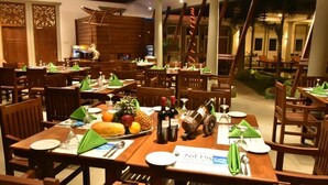 Un comedor con mesas y sillas de madera, servilletas verdes y un menú.