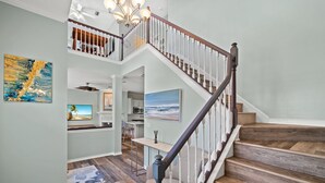 A spacious interior with a wooden staircase, a dining area, and a kitchen.