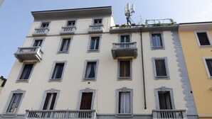 A multi-story building with balconies, windows, and a satellite dish. - VivimiHome - [Navigli-Duomo] Maison Fusetti (Milano)