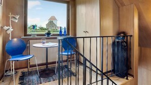 A small room with a window, a table, two chairs, a radiator, and a staircase. - Lovely apartment in Erslev with WiFi (Erslev)
