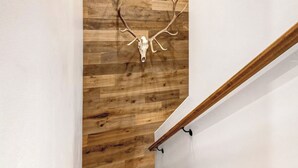 Eine Holztreppe mit einem an der Wand befestigten Hirschschädel.
