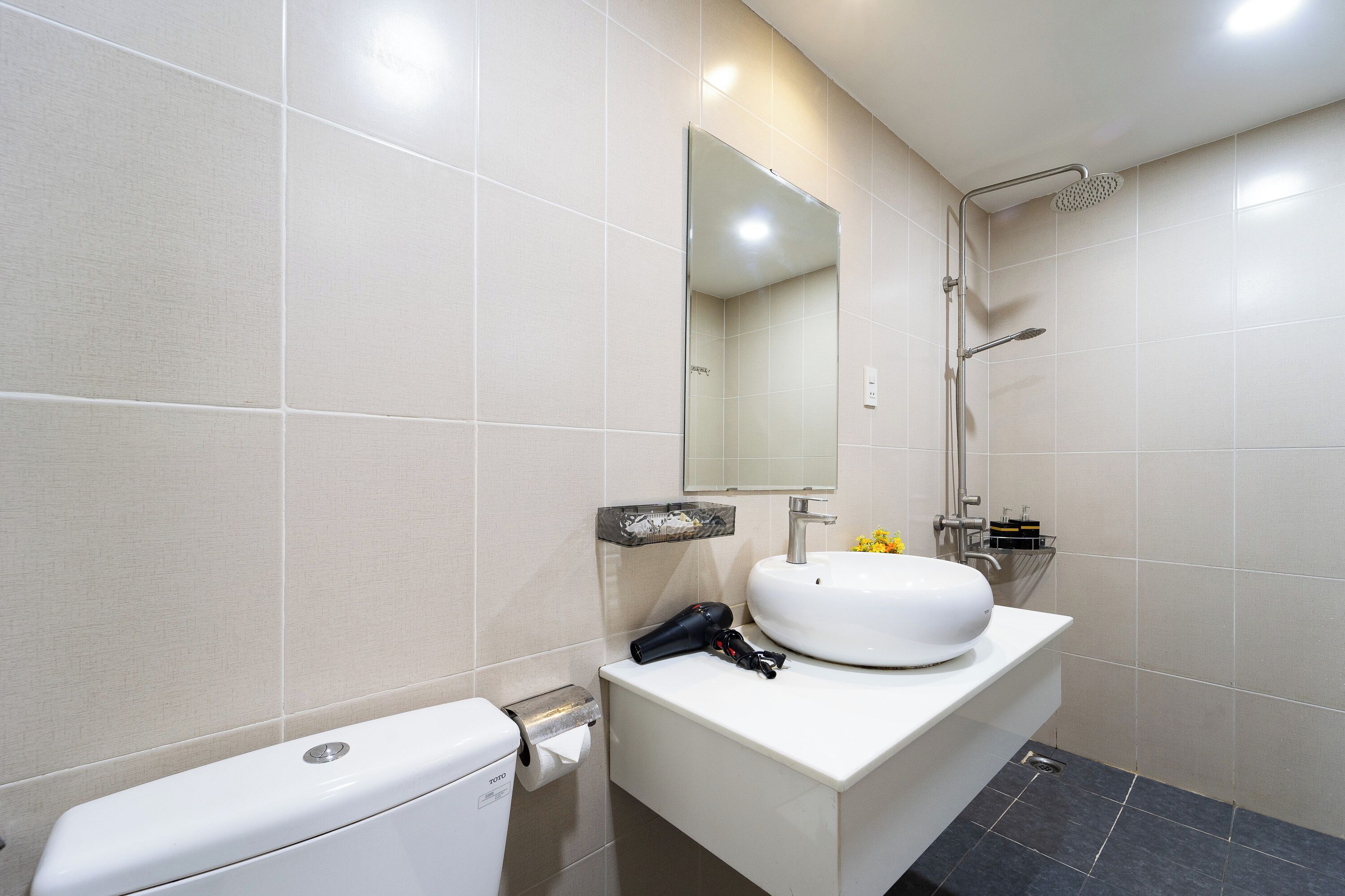 Ein modernes Badezimmer mit Toilette, Waschbecken, Spiegel und Dusche.