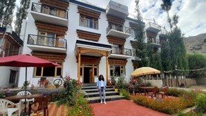 Un edificio de estilo arquitectónico tradicional, con balcones de madera y un acceso con tejas rojas.