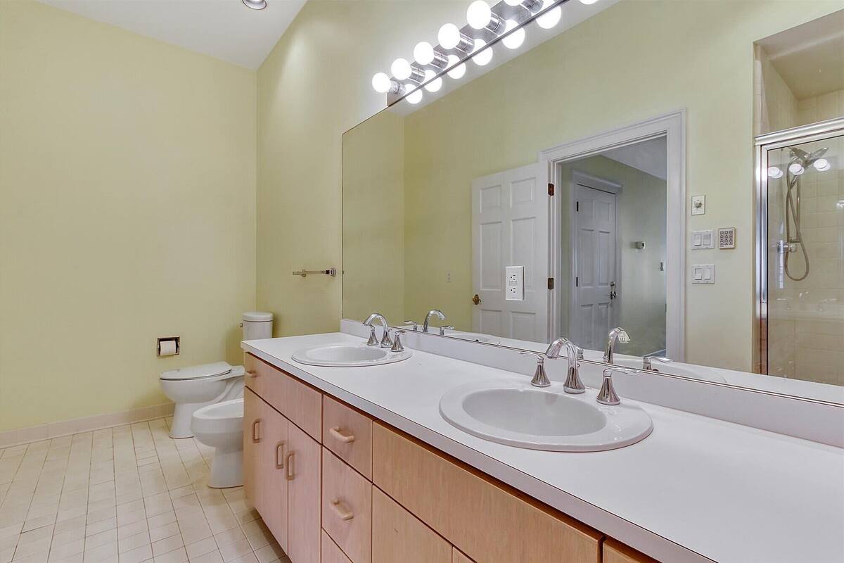 A bathroom with two sinks, a toilet, and a shower.