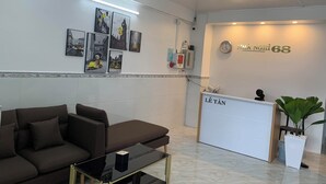 Una zona d'arribada moderna amb taulell de recepció, un sofà i una taula de cafè.