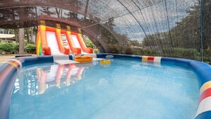 Une piscine gonflable avec des toboggans et des bouées gonflables.