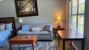 A living room with a sofa, a coffee table, a lamp, and a painting on the wall. - Joyful Place 2 King Bed 2 bath
10 Min to Berry College, Shorter University (Rome)