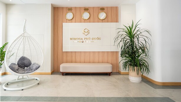 Ein modernes Hotel-Foyerdas einen Hängekorb, eine Bank und einen Topfpflanzen umfasst.