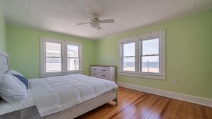 A bedroom with a bed, a nightstand, a dresser, and a ceiling fan. - OCHG SeaFoam Ocean Front5 (Ocean City)