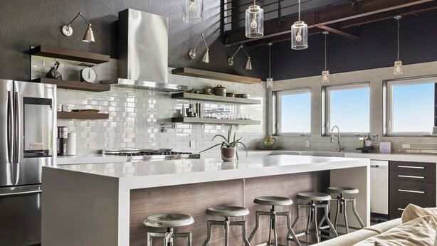 A modern kitchen with a large island, bar stools, and a built-in oven. - Enchanted Rock Ridge / Cowboy Pool / Hot Tub / Firepit (Fredericksburg)