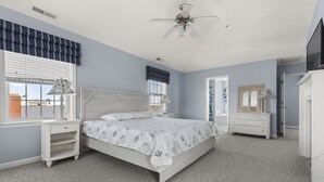 A bedroom with a bed, nightstands, a dresser, a ceiling fan, and a window with blinds. - OCHG Townhouse 102 10 (Ocean City)