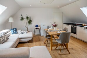 Un appartement moderne de style « loft » comprenant un coin repas, une cuisine et un espace salon.