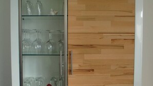 A cabinet with multiple shelves, a glass door, and wooden drawers. - Apartment 'Ferienwohnung Stella Fiante' with Sea View, Balcony and Wi-Fi (Breege-Juliusruh)