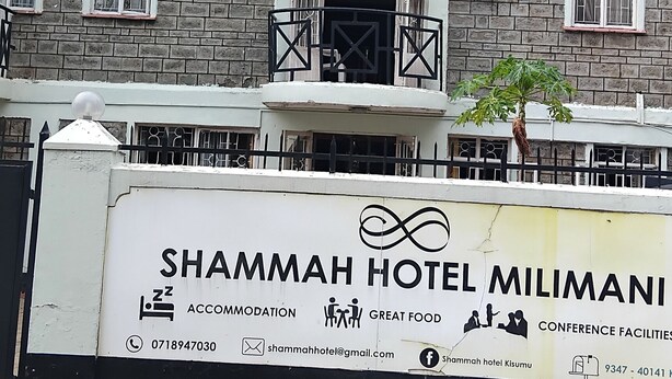 A multi-story hotel with balconies, a signboard for Shammah Hotel Milimani, and a contact number. - shammah hotel ltd (Kisumu)