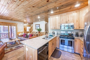 A kitchen with wooden cabinets, a stainless steel stove, and a dishwasher. - Timber Wolf 6B (Park City)