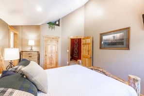 A bedroom with a bed, wooden wardrobe, and a framed picture on the wall. - Timber Wolf 6B (Park City)