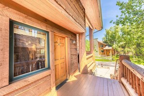 A wooden cabin with a deck, a door, and a window. - Timber Wolf 6B (Park City)