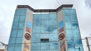 Un edificio moderno con fachada de vidrio, el nombre "BENJAMIN I" en la parte frontal y una entrada visible con una reja metálica.