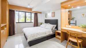 Un dormitorio moderno con una cama, un escritorio y una silla.