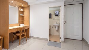 Un baño moderno con tocador de madera, un lavabo y un espejo.