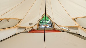 A tent with a central table and chairs, and a view of greenery outside. - NA SUN NA GU (Nan-ao)