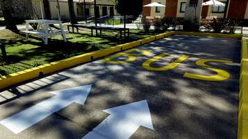 A parking area with a bus stop sign and directional arrows.
