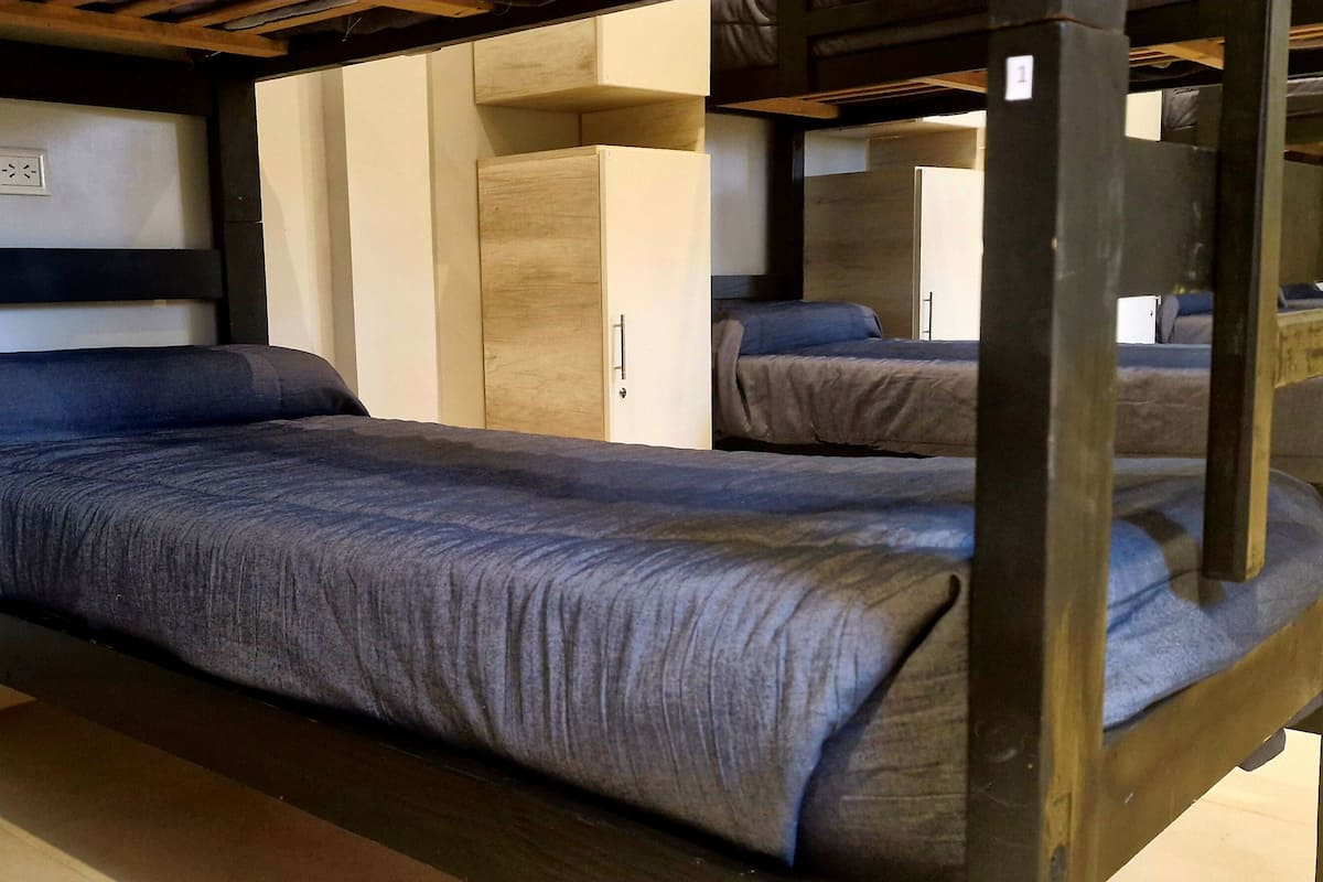 Un lit superposé avec une tête de lit, une table de chevet et un miroir.