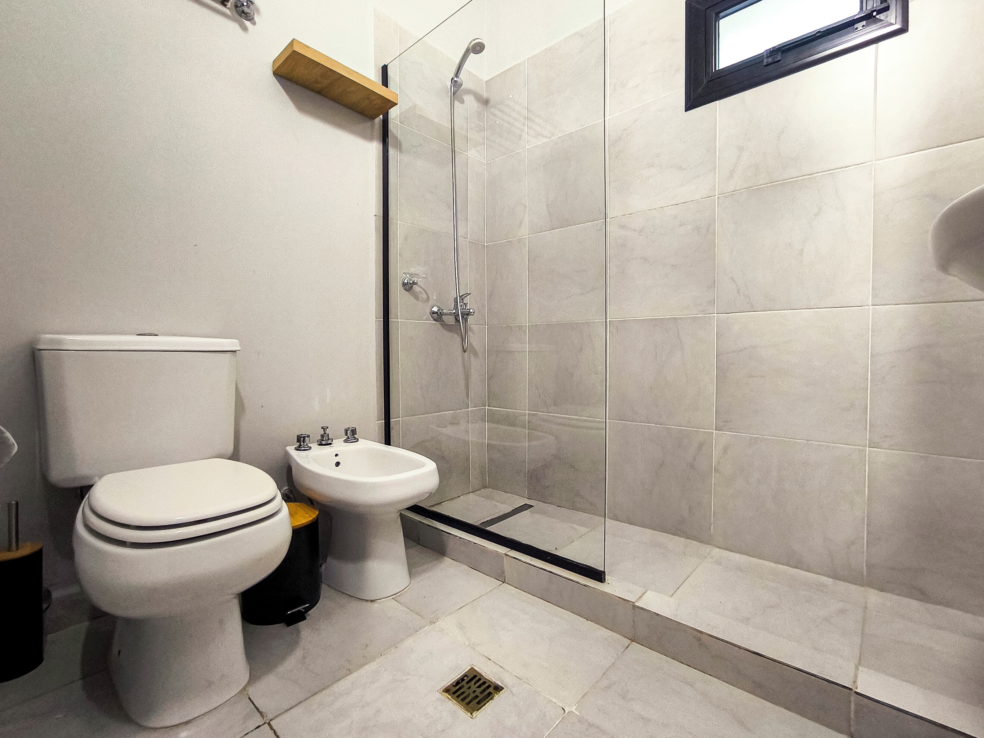A modern bathroom with a toilet, bidet, and shower.