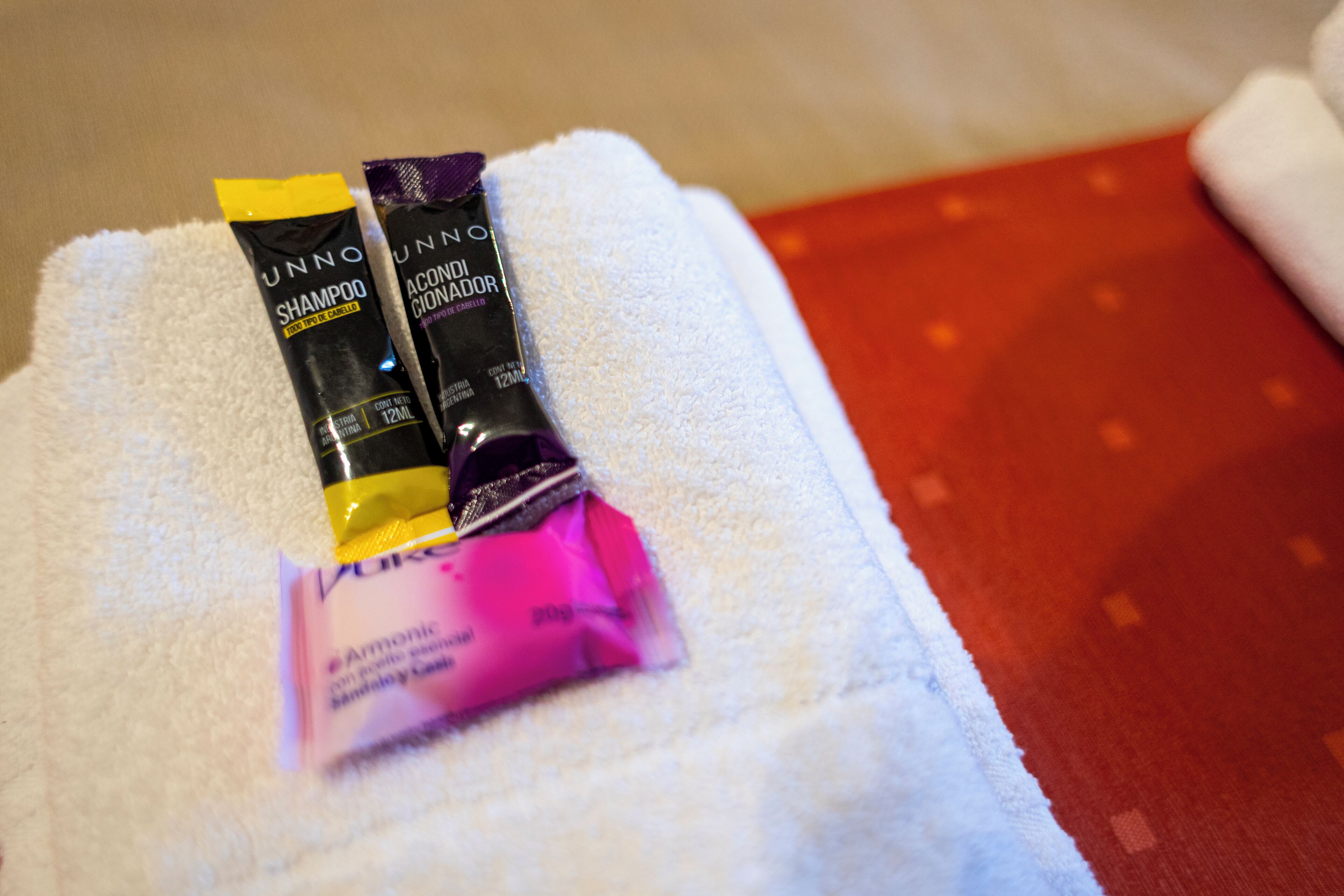 A white towel with three hair care products on it.