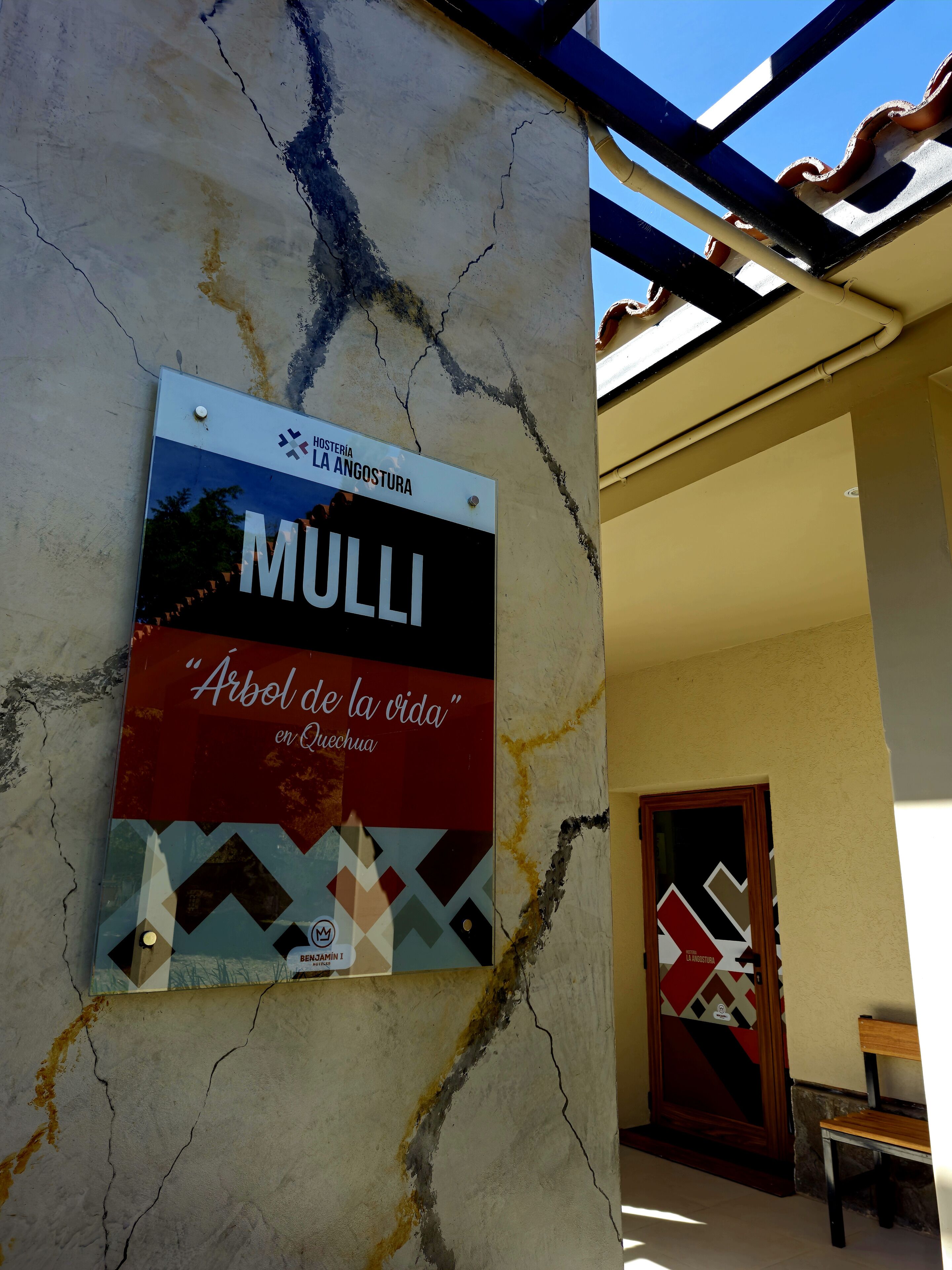 A sign for 'MULLI' with a red and blue design, a plaque, and a door with geometric patterns.