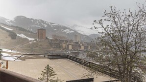 A mountainous town with buildings, a ski lift, and a view of snow-capped mountains. - Nice studio 4 pers near the slopes (Orcières)