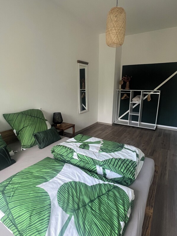 Une chambre à coucher avec un lit, une lampe suspendue, un miroir et une armoire.