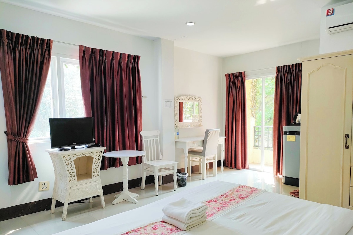 Une chambre d’hôtel comprenant un lit, un bureau, une chaise, une télévision et une armoire.