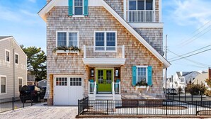A two-story house with a front porch, a garage, and a driveway.