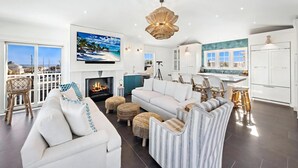 A modern living room with a fireplace, a television, and a balcony with a view.