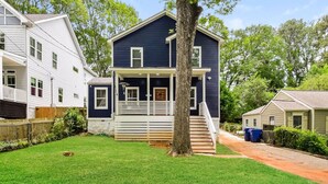 A two-story house with a front porch, a staircase leading to the second floor, and a well-maintained lawn. - The Kirkwood Escape!! (Atlanta)