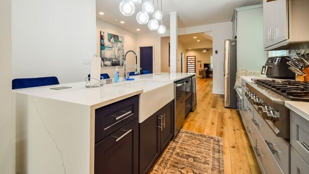 A modern kitchen with a central island, stainless steel appliances, and pendant lighting. - The Kirkwood Escape!! (Atlanta)