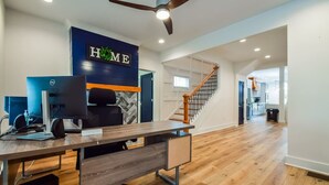 A spacious room with a wooden desk, a computer, and a "HOME" sign on the wall. - The Kirkwood Escape!! (Atlanta)