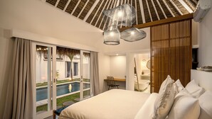 Une chambre avec un grand lit, un bureau et une vue sur une piscine.