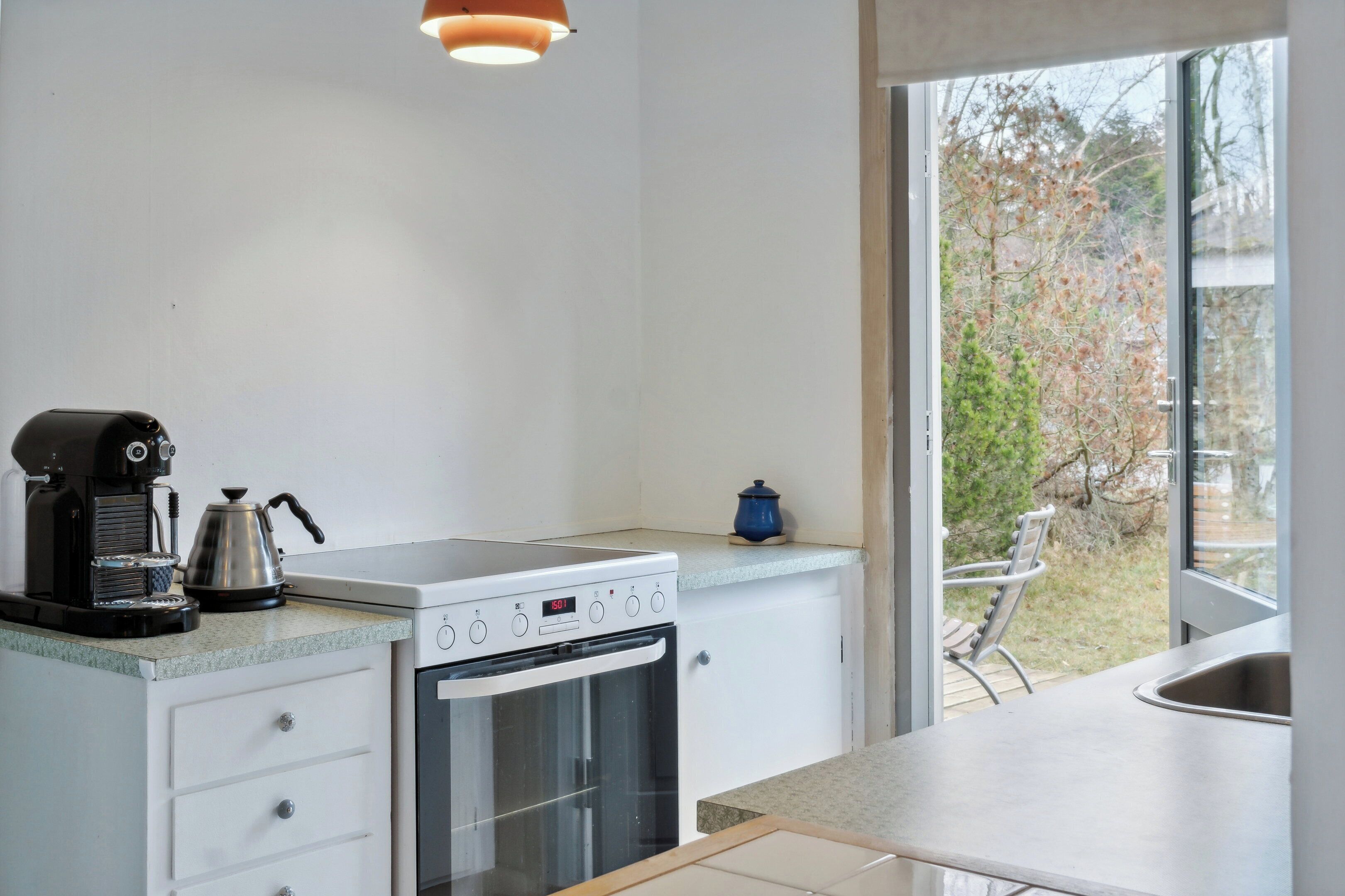 Una cocina equipada con estufa, horno y cafetera.