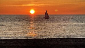 Un sol de tramuntana sobre l'oceà amb un veler.