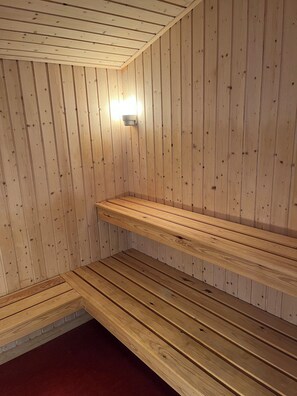 Sauna, jossa on puuseinät ja -lauteet.