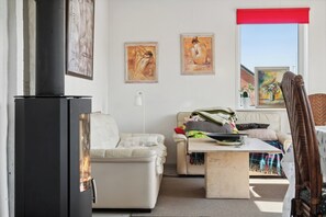 A living room with a fireplace, a sofa, a coffee table, and artwork on the wall.