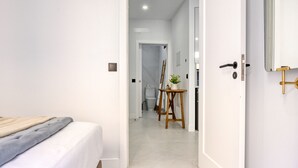A bedroom with a bed, a wooden headboard, and a bedside table. - Beco Santa Emilia 2I, a Home in Madeira (Funchal)
